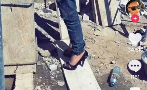 Albañil ingenioso usa un par de tacones en una obra a falta de escalera